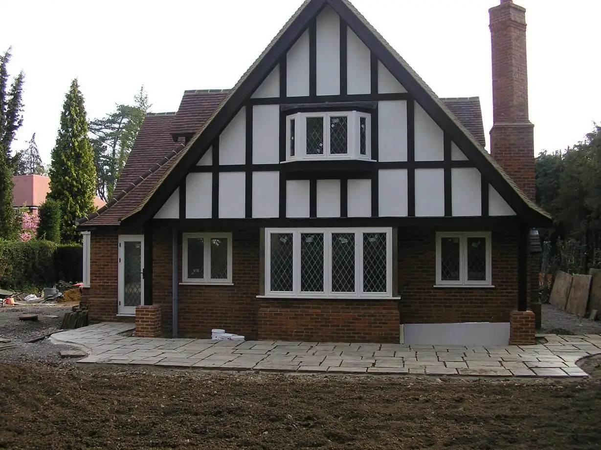 Tudor-style house exterior with stone patio — building work by AVA Construction, Truro Cornwall